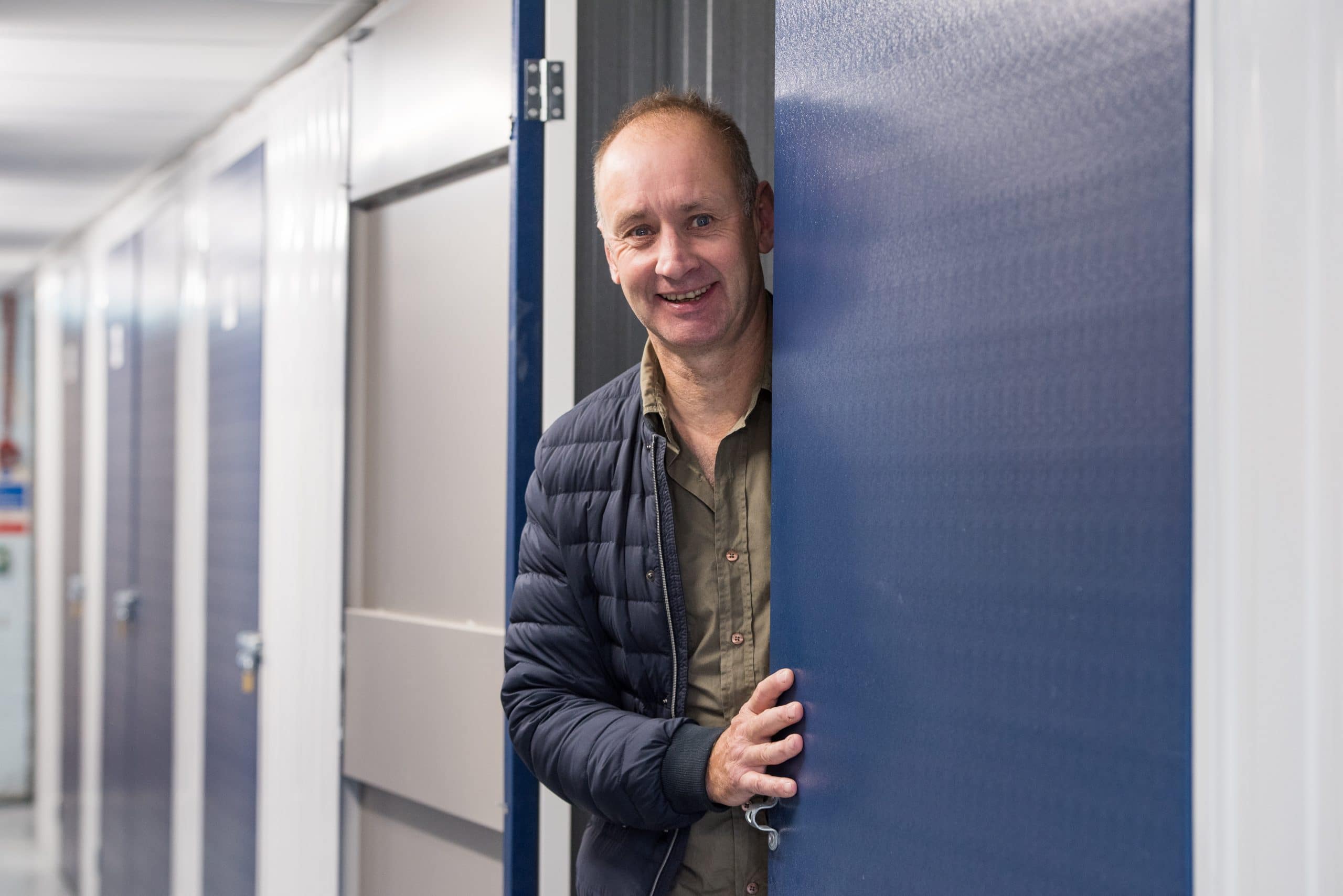 A man standing at the entrance of a storage unit