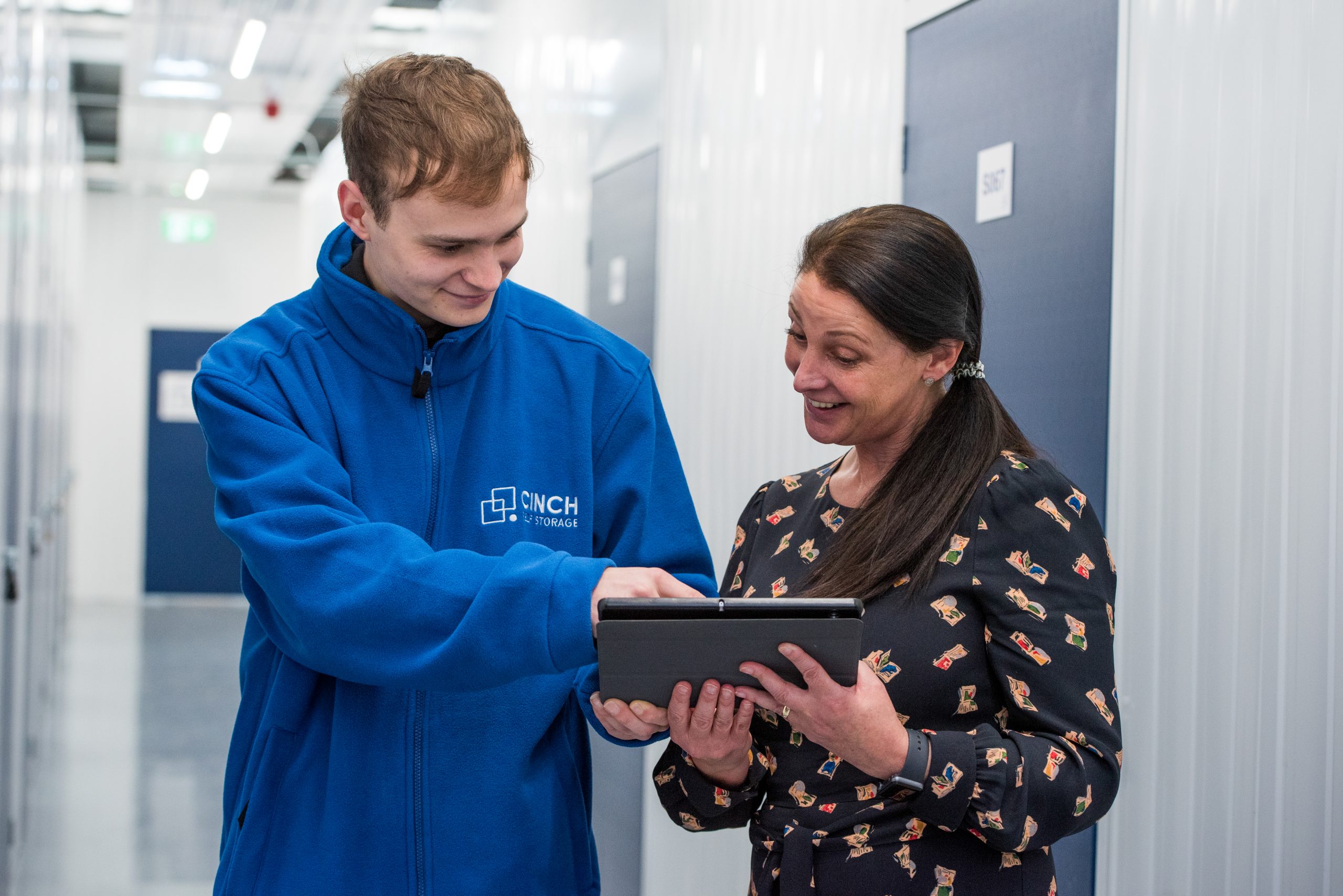 Cinch self storage staff showing women where she can find unit