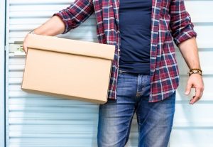 A man holding a box outside storage facility