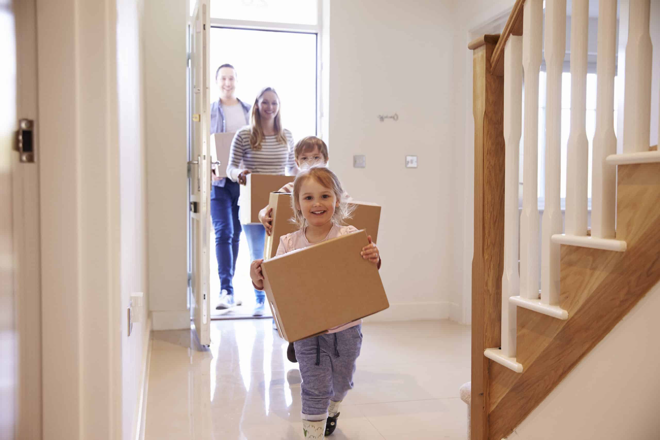 Family with boxes running into new house moving house Brighton