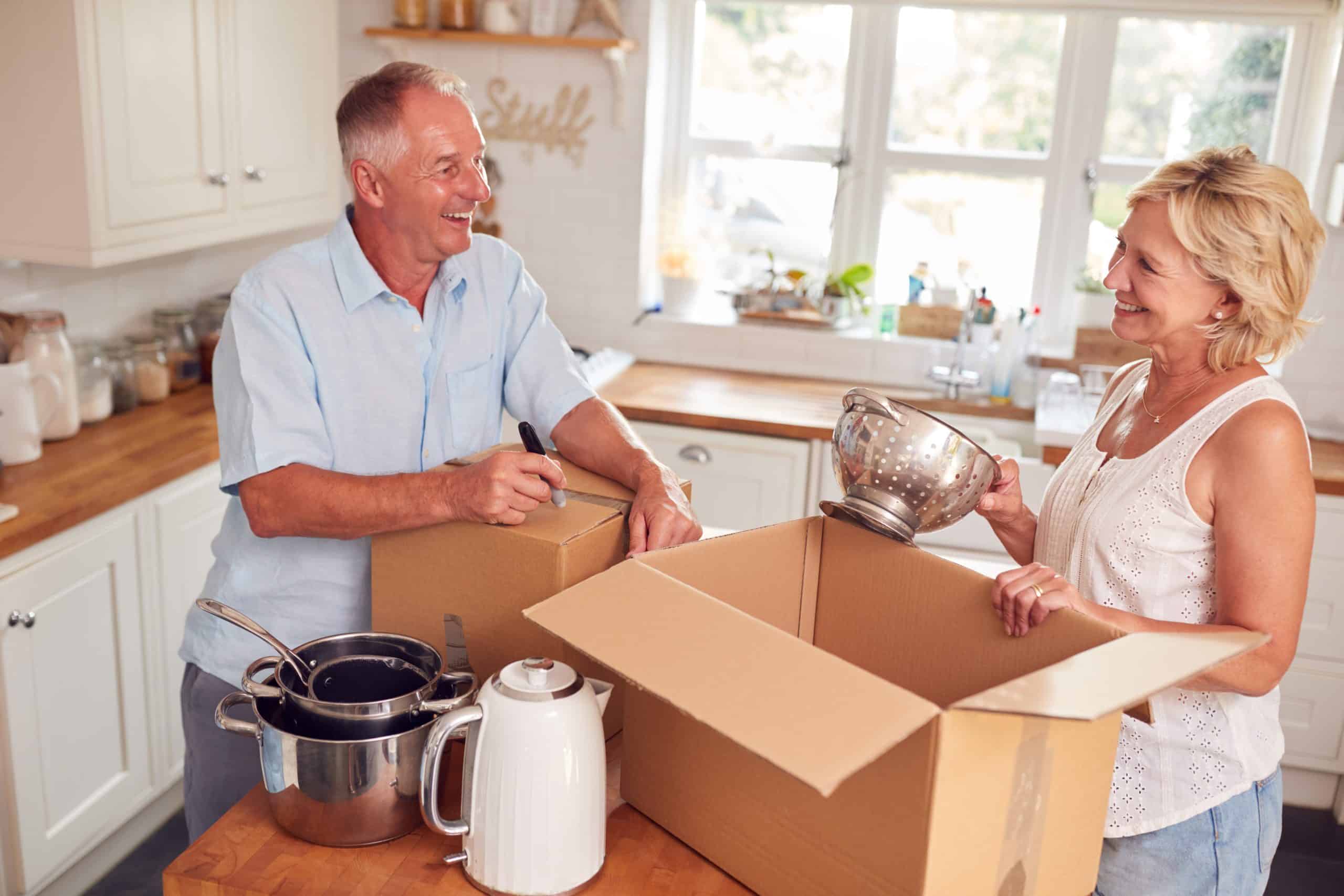 Storage facilities in Brighton and Hove - image shows a couple smiling together packing kitchen items into a cardboard box in their kitchen