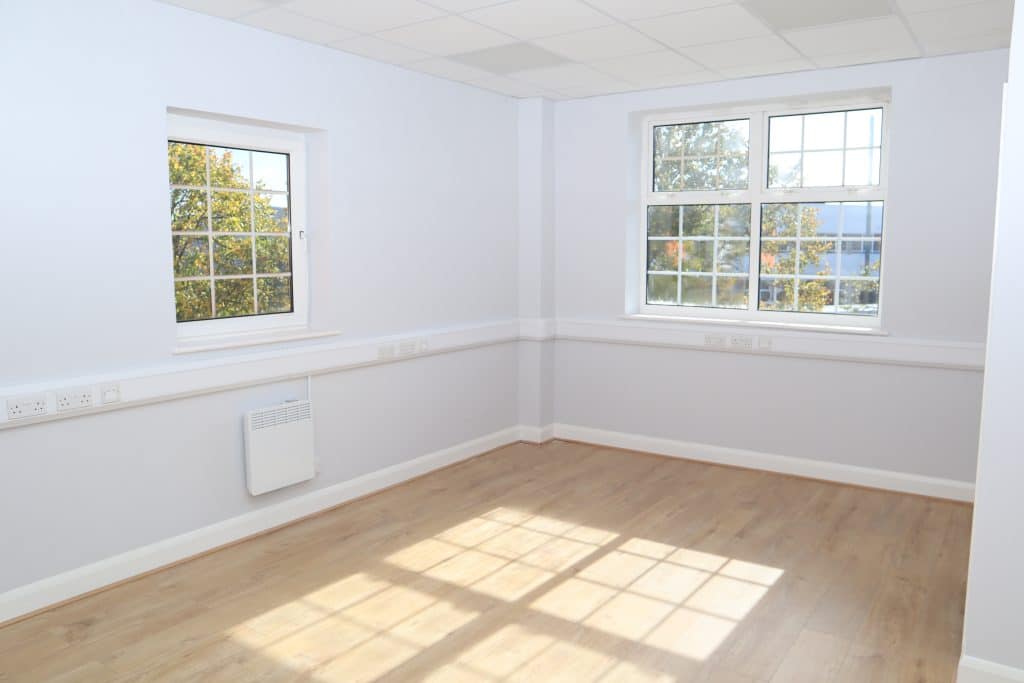 Chippenham Office Space: Start your business in this vibrant West Country town. Image shows an empty office space with double windows and light brown floor with sunlight flooding in.