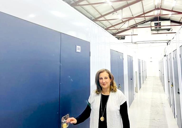 Cemre Koccat Case Study. Image shows Cemre standing in front of her storage unit. 
