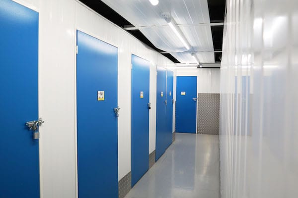 Storage Bicester. Image shows a corridor of storage units with blue doors. 