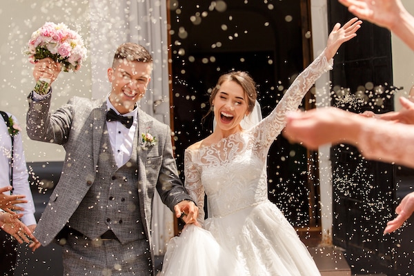 Storage facilities in Brentwood. Image shows happy couple in wedding dress and suit with arms in the air and confetti being thrown.