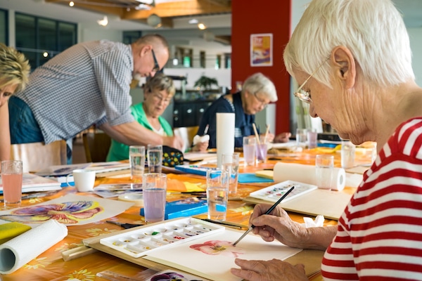 Storage in Watford. Image shows an elderly group sitting at a table painting watercolours. 