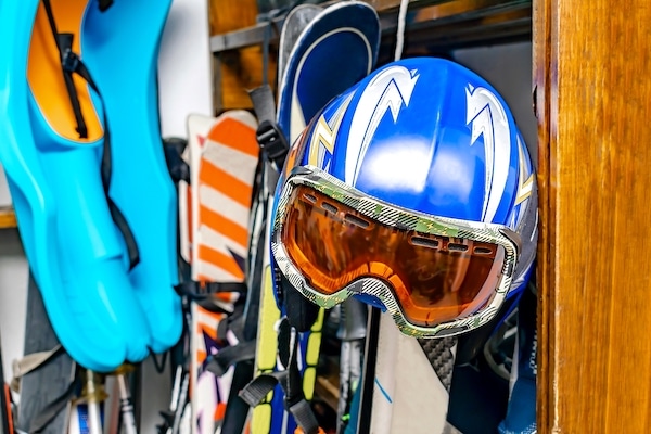 Storing for sports. Image shows a ski helmet, skis, diving flippers and other sports equipment hanging up.