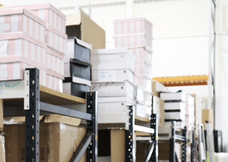 watford_business_storage. Image shows business stock in striped pink and white boxes stacked on top of shelf racking in a storage unit.