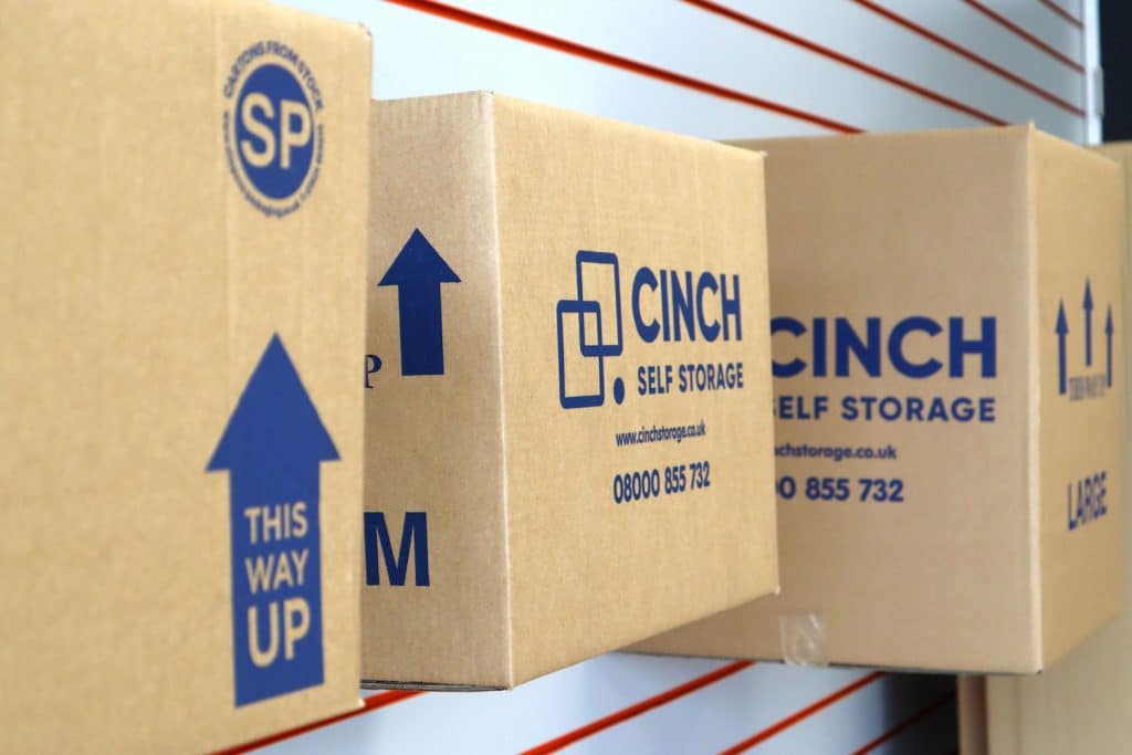 5 creative ways to reuse your moving boxes. Image shows Cinch Self Storage cardboard boxes mounted on a wall. 