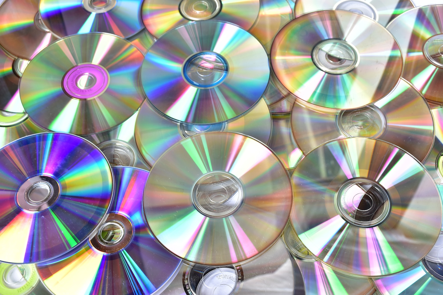 Image shows pile of old dirty used cds and dvds