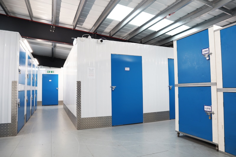 storage_unit_in_Woking. Image shows a hallway with storage units with blue doors. 