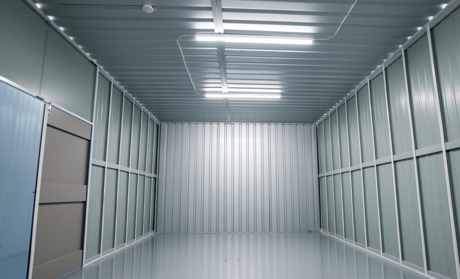 7 benefits of renting an industrial unit for your business. Image shows the inside of a large industrial unit with strip lighting on the ceiling.