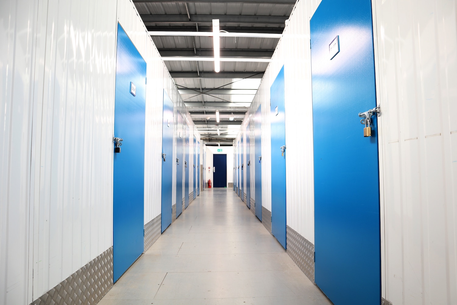 Storage unit in Enfield. Image shows the corridor of a storage unit facility with blue doors on either side.
