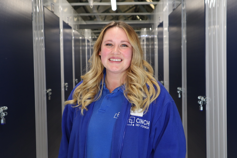 5 benefits of business storage in Letchworth. Image shows a Cinch Self Storage employee standing in between the corridor of storage units.
