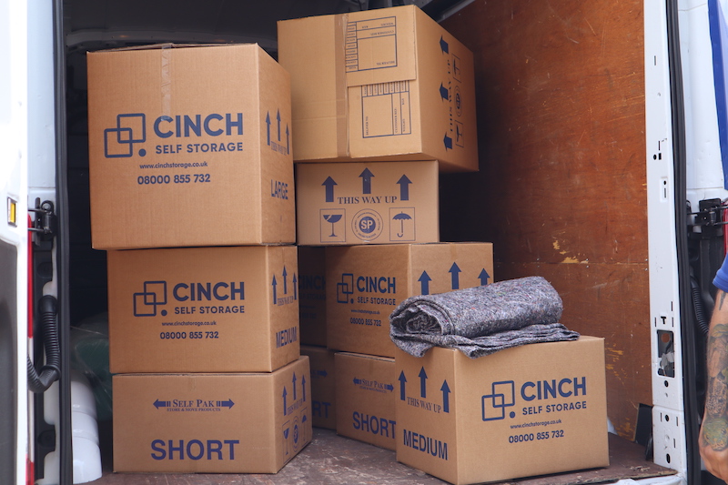 5 reasons why you should move. Image shows the back of a van open with lots of Cinch Self Storage cardboard boxes and a packing blanket