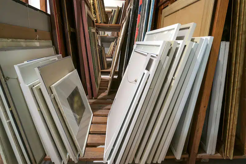 Tips for storing art: a comprehensive guide. Image shows frames stacked against each other.