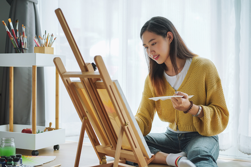 Storage facilities in Dunstable. Image shows a female artist in a yellow cardigan painting a canvas