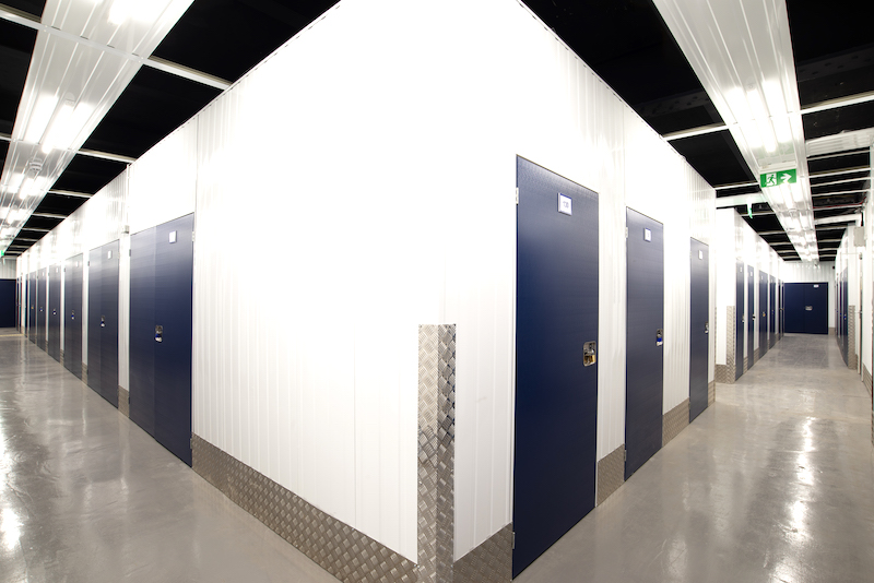 Storage facilities in Sidcup. Image shows the interior of a storage facility with a corridor with blue doors.