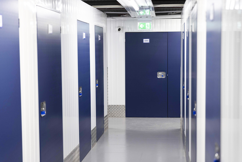 Storage unit to rent Sidcup. Image shows the interior of a storage unit facility corridor with blue doors leading to storage units.