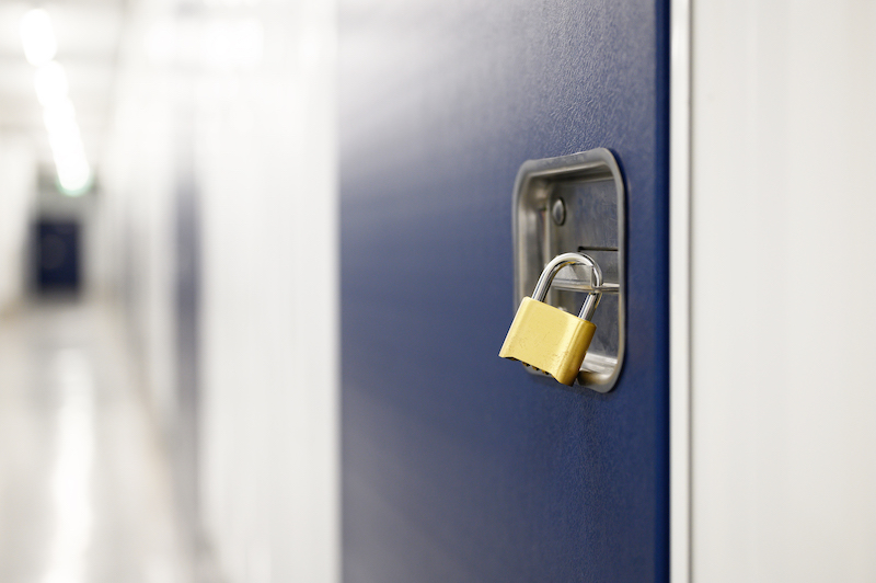 Temporary storage Sittingbourne. Image shows a gold padlock close up on a blue storage unit door.