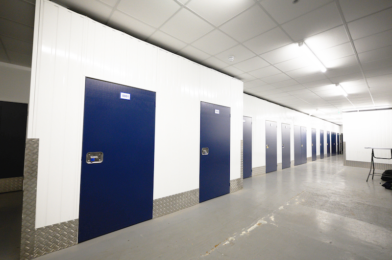 Storage unit in Woking. Image shows corridor with blue storage unit doors on either side. 