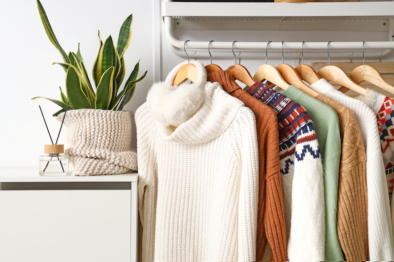 Storage Southend. Image shows a hanging rack with stylish sweaters and ear muffs on rack near light wall