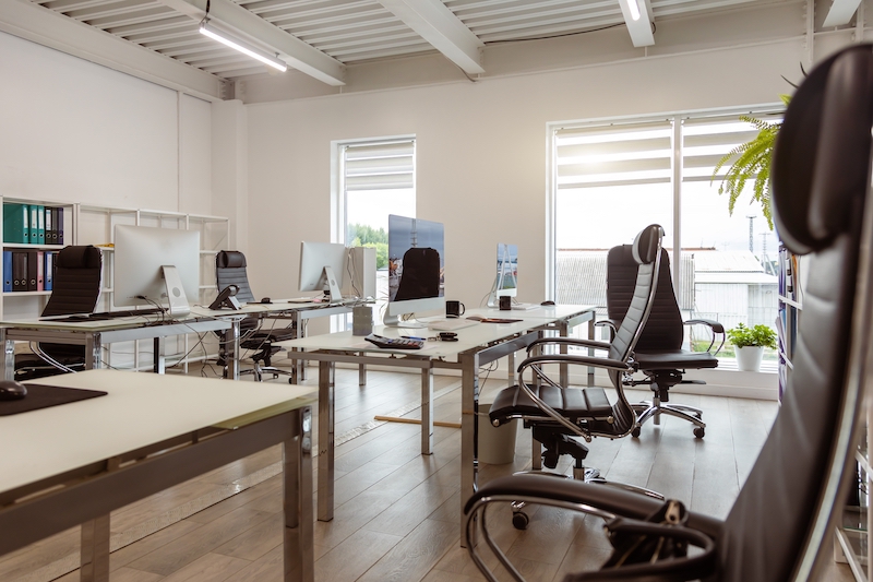 Office to rent Woking. Image shows a light and airy office with desks, computers and desk chairs.