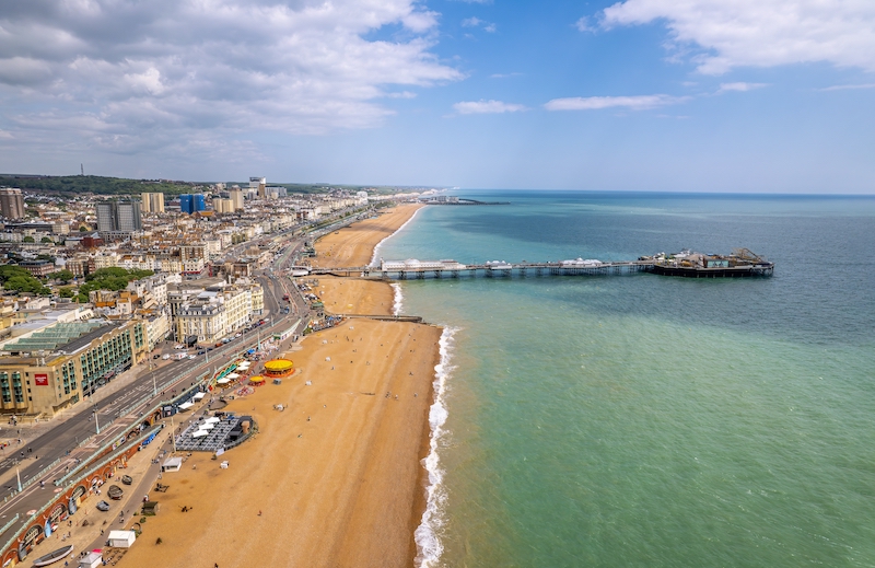 5 benefits of living in Brighton. Image shows the drone aerial view of Brighton Pier and the beach of Brighton. 