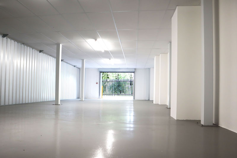 Self storage in Letchworth. Image shows an empty enterprise unit with white walls and an open roller door. 