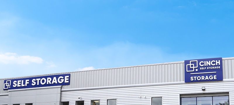 Storage Sittingbourne. Image shows large blue sky with Cinch Self Storage facility and blue signs on building exterior.