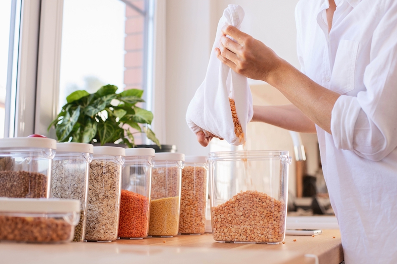 Storage facilities in Bedford. Image shows woman pouring cereal into a plastic tub in her kitchen.