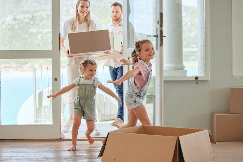 House move storage Earlsfield. Image shows children, running into their new home with their parents carrying boxes.