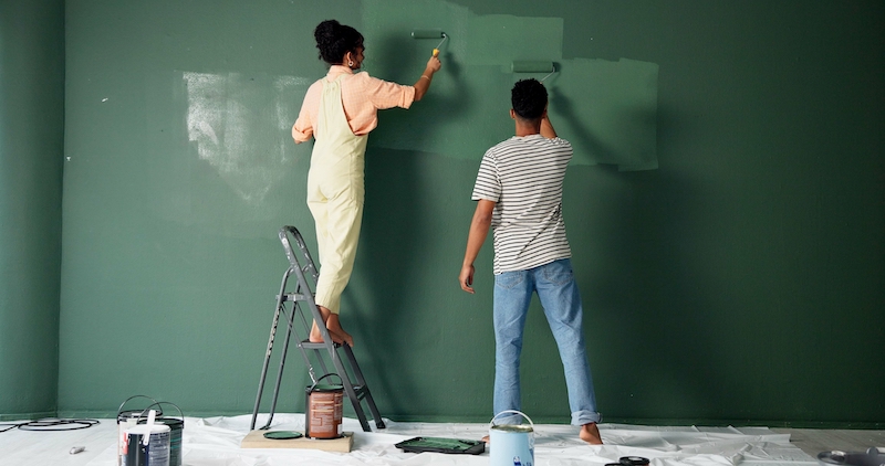 Storage Swindon. Image shows a couple painting the walls in their home green, during their home renovations.