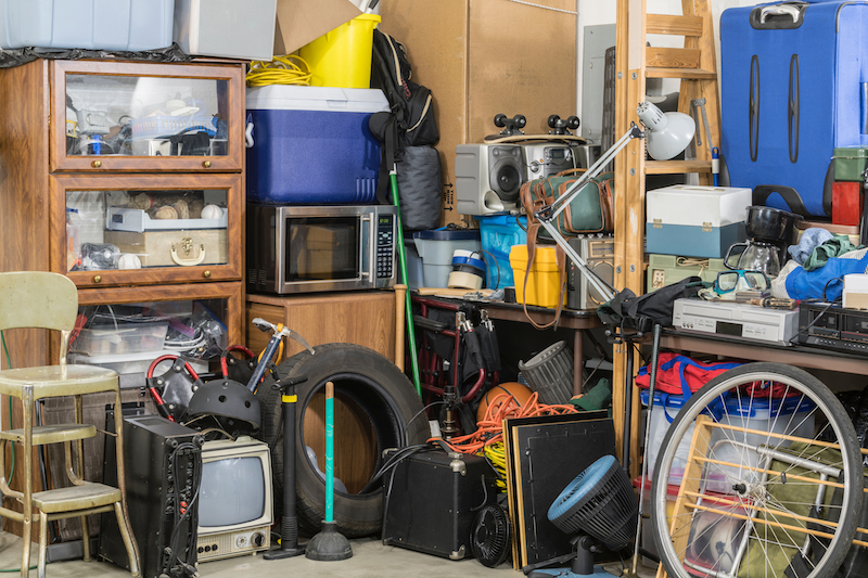 Decluttering tips for hoarders. Image shows a lot of clutter in a garage.