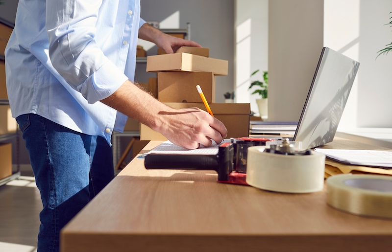 Bedfordshire business storage. Image shows man holding a pencil and shipping e-commerce orders.