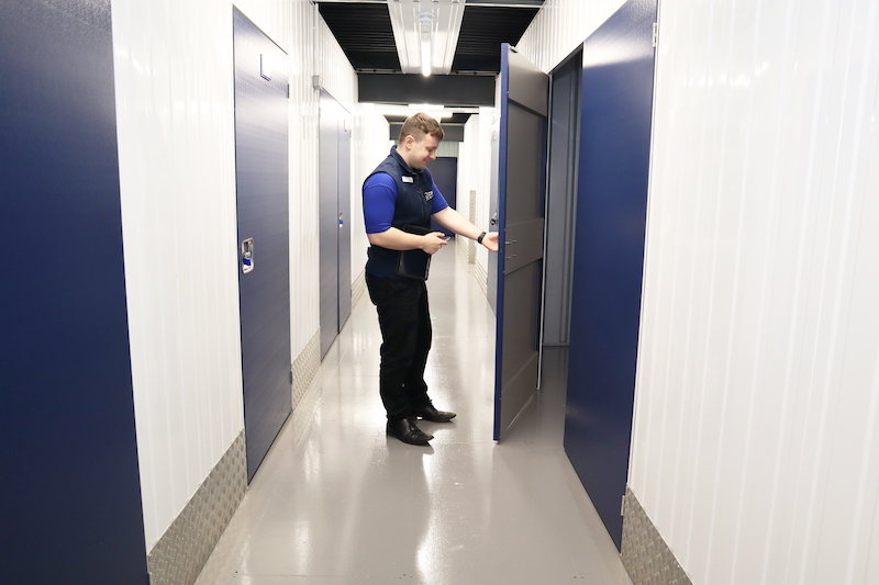 6 best places to live in Bedfordshire. Image shows a Cinch Self Storage employee opening up the door of a storage unit at Cinch Storage Bedford.
