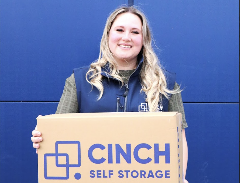 Bedfordshire short-term storage. Image shows a Cinch Self Storage employee holding a Cinch cardboard box.