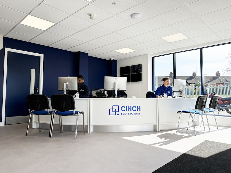 Image shows a Cinch Self Storage reception area, with two employees sitting at the desk ready to welcome customers.