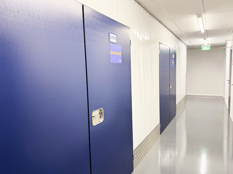 Self storage in Kent. Image shows the interior corridor of a self storage facility with blue self storage doors.