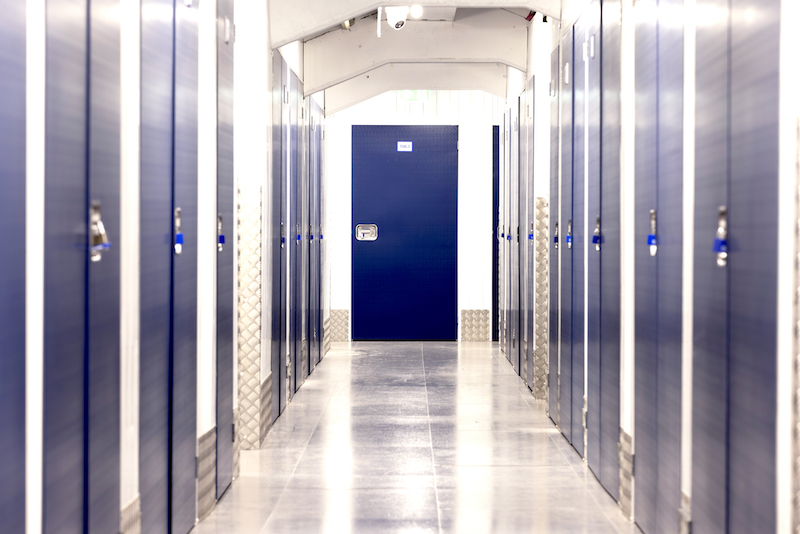 Storage in Wisbech. Image shows corridor of storage units with blue doors.