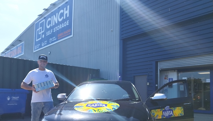 Kasabia Drinks Cinch Storage Case Study. Image shows founder standing holding drinks in front of Cinch Self Storage Bicester.