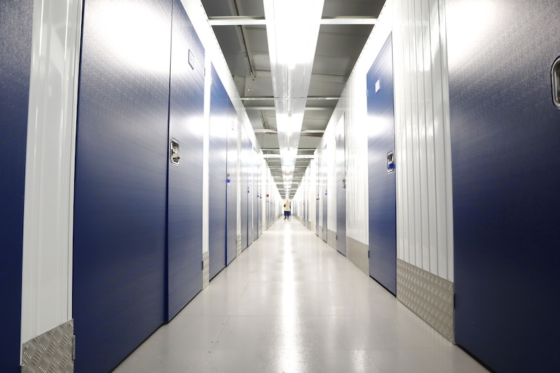 Storage rooms Wisbech. Image shows a corridor with blue door storage units.