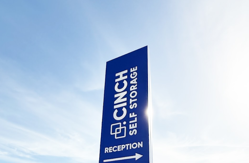 Affordable Bicester storage. Image shows a Cinch Self Storage external sign pointing to reception in front of blue skies.