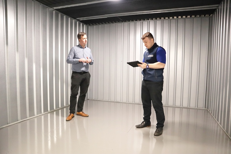 Cheap storage in Bedford. Image shows two men standing in a storage unit discussing things at Cinch Storage Bedford.