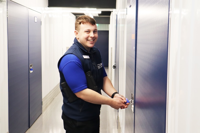 Short term storage in Wisbech. Image shows a cinch storage employee putting a padlock on a storage unit door.