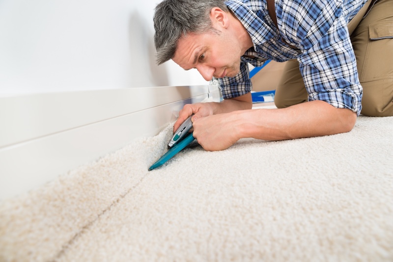 Storage for tradespeople. Image of a carpet fitter - a man is fitting a carpet.