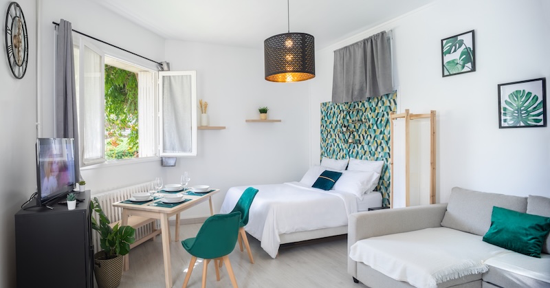Airbnb self storage. Image shows a bedroom set up as an airbnb with a dining table and sofa area.