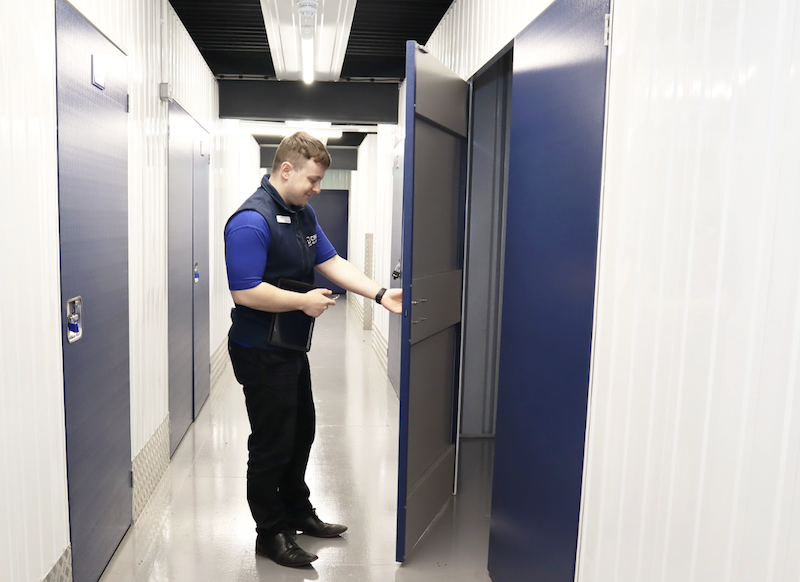 Self storage near Dower Market. Image shows a Cinch Storage employee opening the door to a storage unit.