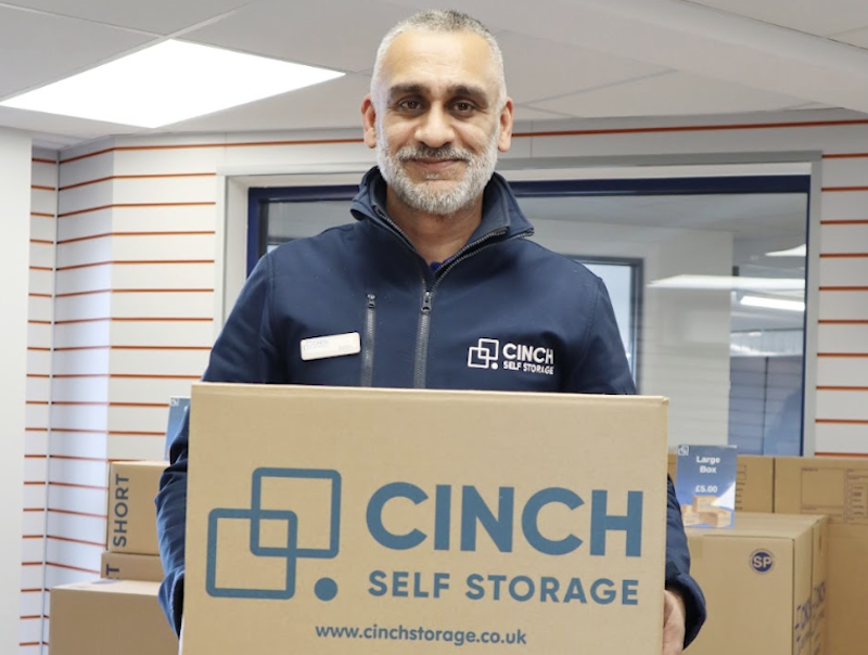 Self storage near Kings Lynn. Image shows a Cinch Self Storage employee holding a cinch self storage box.
