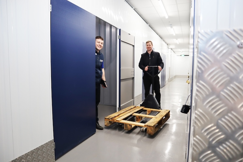 Long term storage Bedford. Image shows a man standing with a pallet outside his storage unit with a Cinch storage employee.